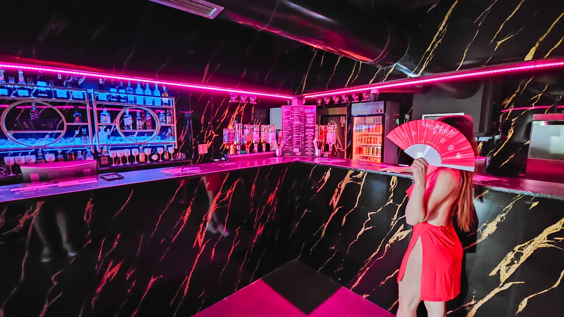 Koktejlový bar s růžovým neonovým osvětlením
