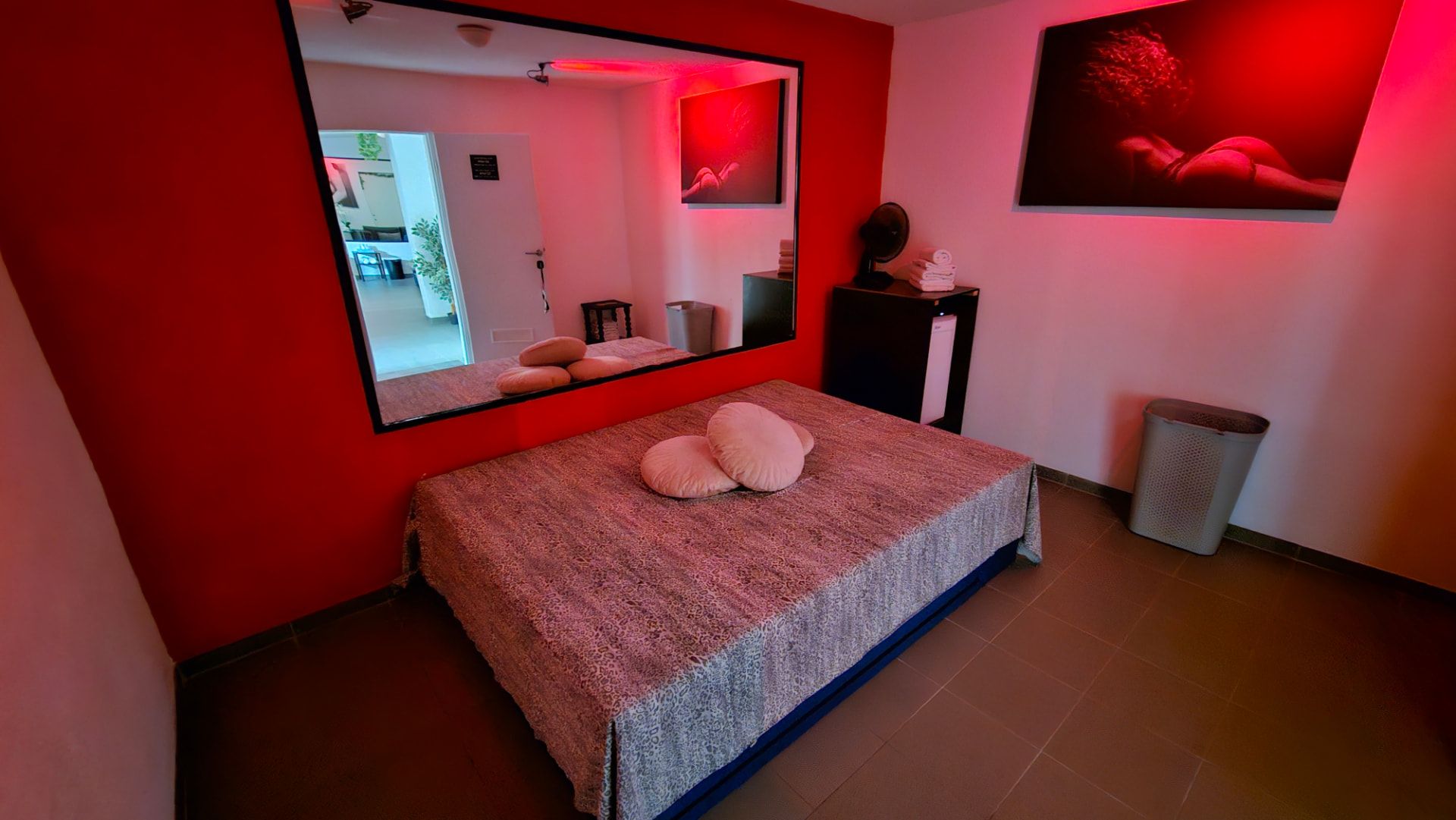 Soukromý apartmán v červeném osvětlení se zrcadlem
